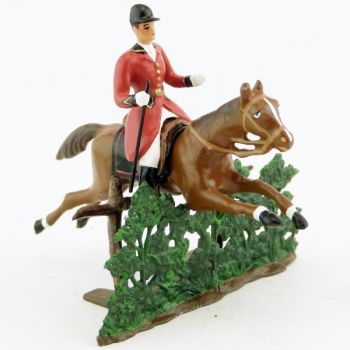 cavalier avec cravache sur cheval alezan sautant haie + barrière