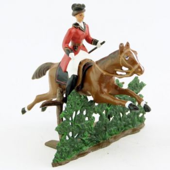 cavalière (cravache) sur cheval alezan sautant haie + barrière