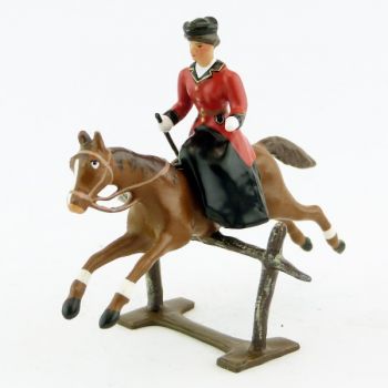 cavali&egrave;re en amazone sur cheval alezan sautant barri&egrave;re